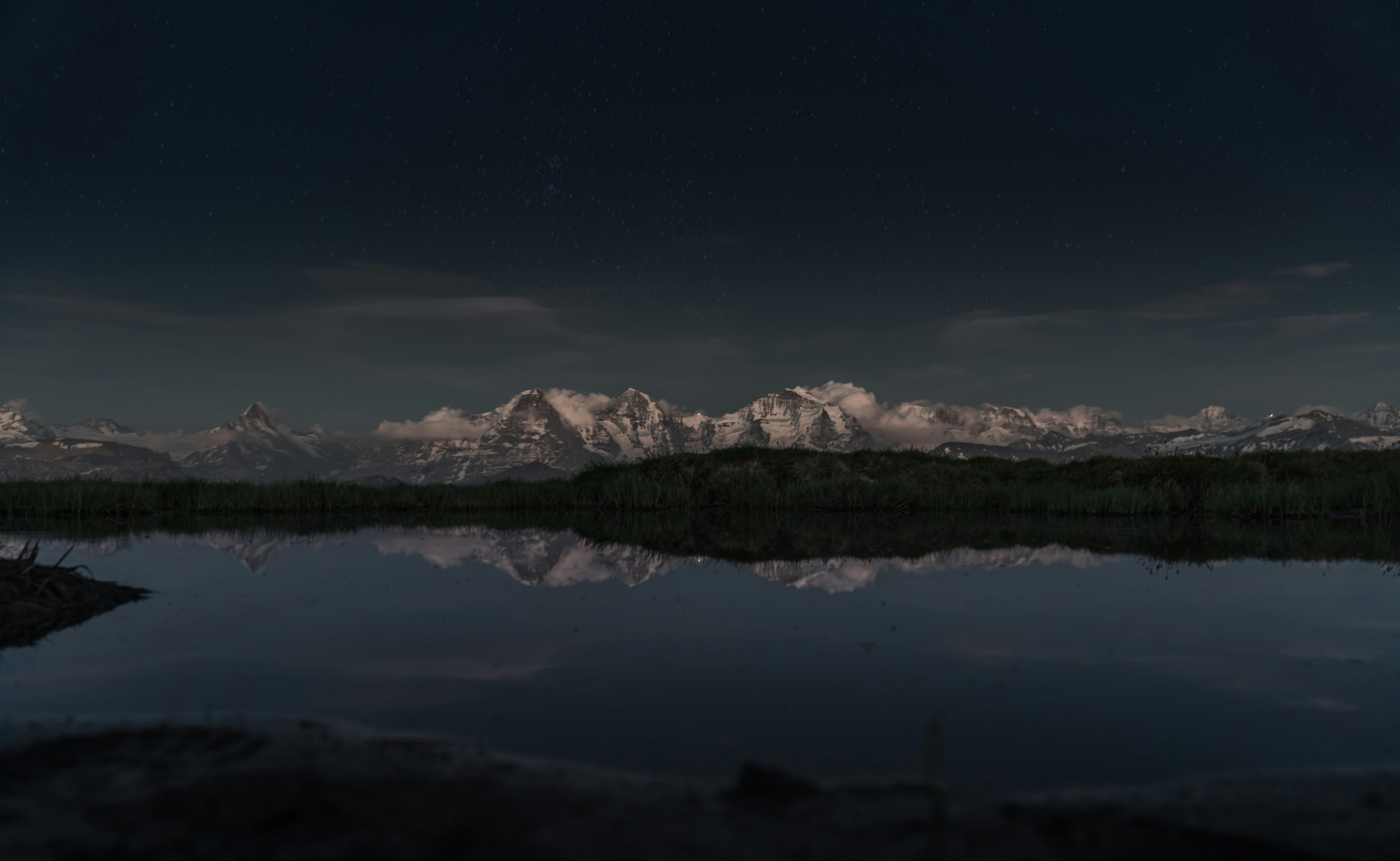 snow covered mountain near lake during night time